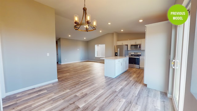 kitchen with an inviting chandelier, a kitchen island, light hardwood / wood-style floors, and stainless steel appliances