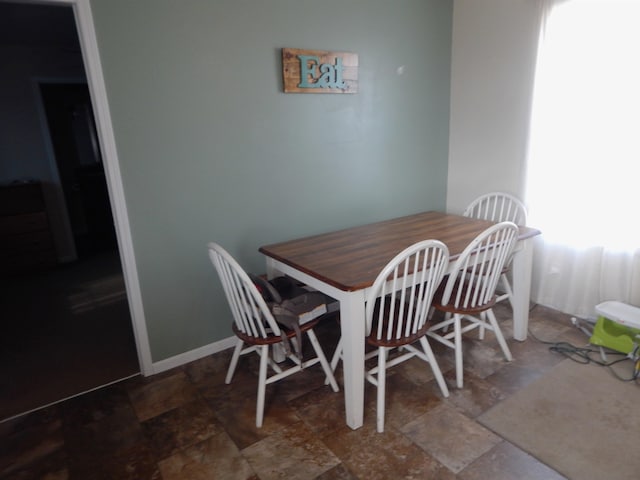 dining room with stone finish floor and baseboards