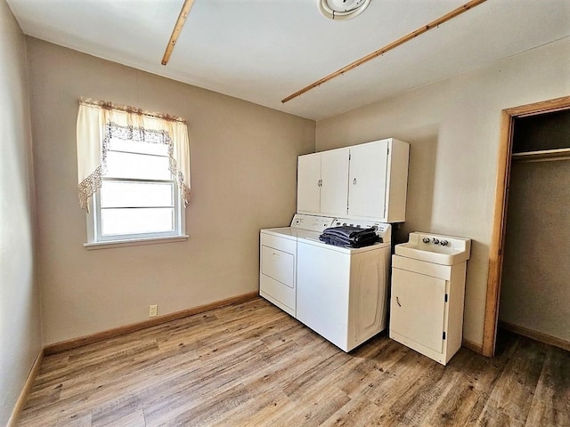 810 2nd Ave, Kenmare, ND 58746 - laundry area featuring washer and dryer, light hardwood / wood-style floors, and cabinets