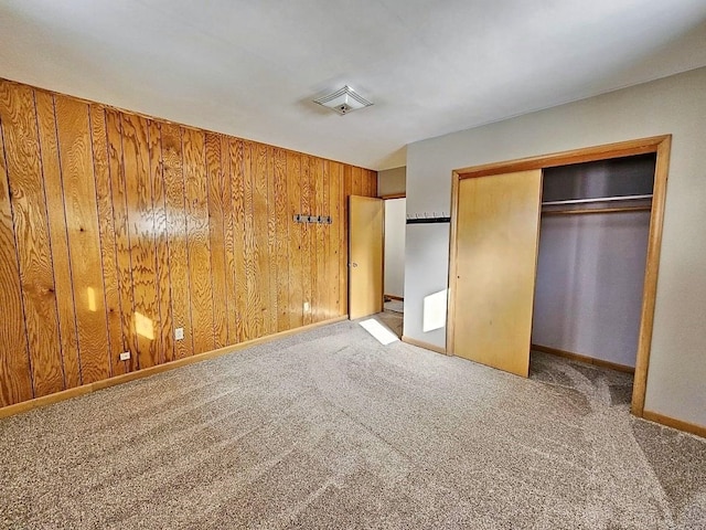 810 2nd Ave, Kenmare, ND 58746 - unfurnished bedroom featuring wooden walls, light colored carpet, and a closet