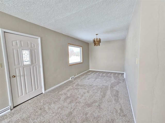 810 2nd Ave, Kenmare, ND 58746 - carpeted spare room with an inviting chandelier and a textured ceiling