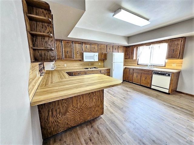 810 2nd Ave, Kenmare, ND 58746 - kitchen with kitchen peninsula, light hardwood / wood-style flooring, white appliances, backsplash, and sink