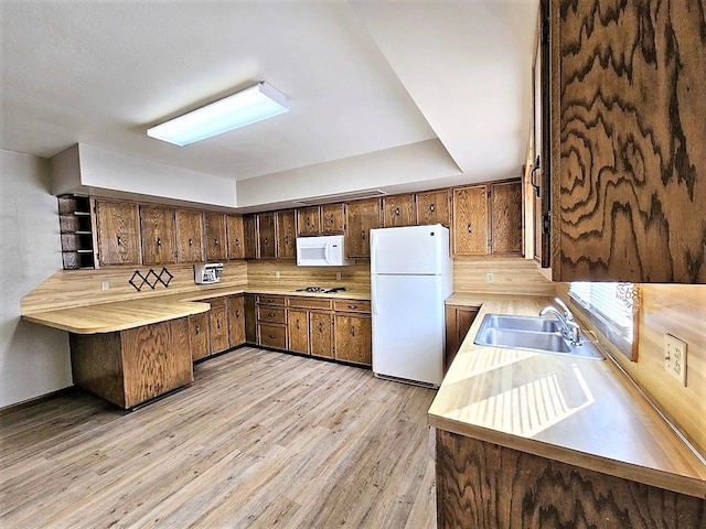 810 2nd Ave, Kenmare, ND 58746 - kitchen featuring tasteful backsplash, a skylight, light wood-type flooring, white appliances, and sink