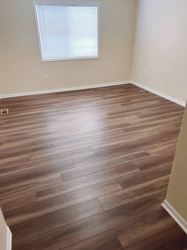 spare room featuring dark wood-type flooring