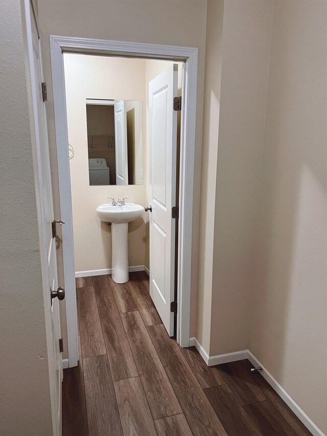 bathroom featuring wood-type flooring, sink, and washer / dryer