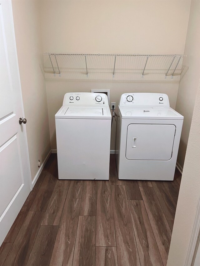 clothes washing area with hookup for a washing machine, separate washer and dryer, and dark hardwood / wood-style floors