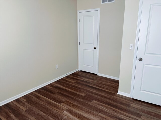 unfurnished room featuring dark wood-type flooring