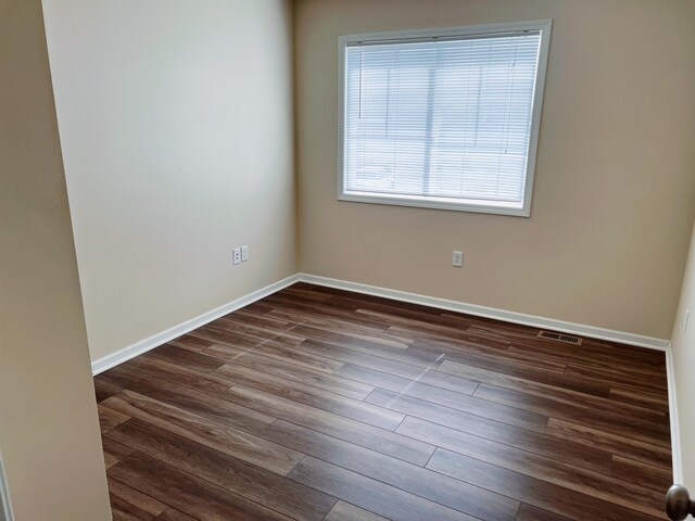 spare room with dark hardwood / wood-style floors