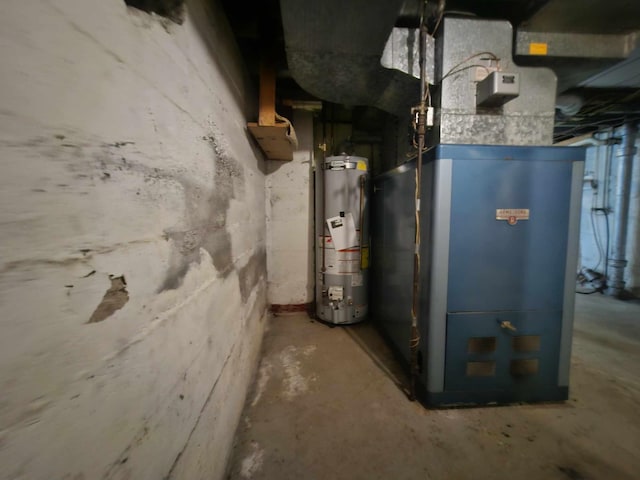 utility room featuring heating unit and gas water heater