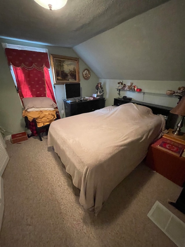 carpeted bedroom featuring vaulted ceiling and a textured ceiling