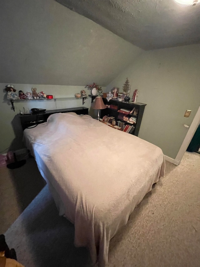 carpeted bedroom featuring vaulted ceiling and a textured ceiling