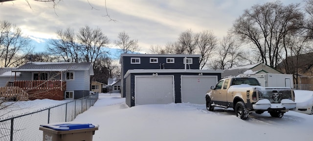 view of front of property with a garage, an outbuilding, and a deck