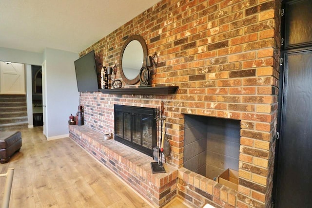 living room with light hardwood / wood-style flooring and a brick fireplace