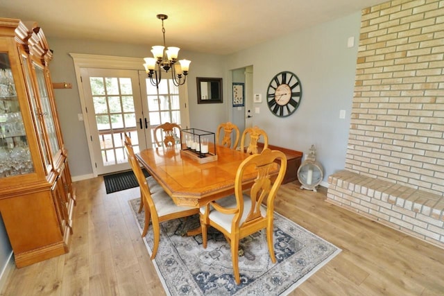 dining space featuring a chandelier, light hardwood / wood-style flooring, and french doors