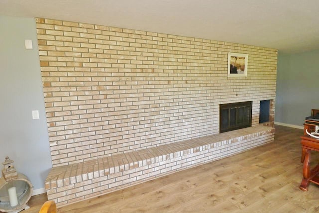 living room with light hardwood / wood-style floors and a brick fireplace