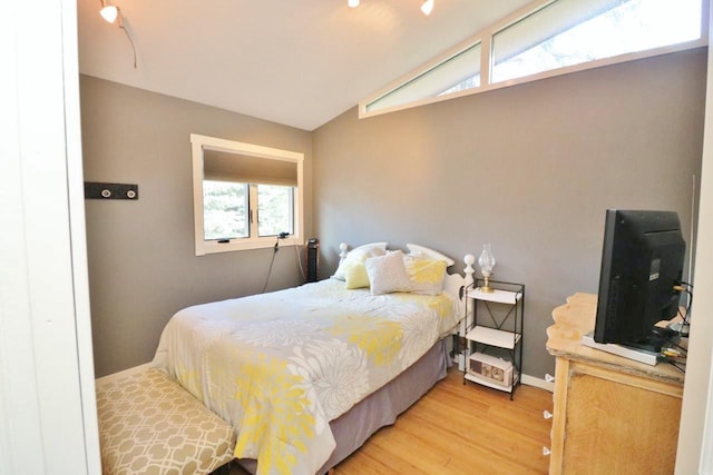 bedroom with wood-type flooring and vaulted ceiling