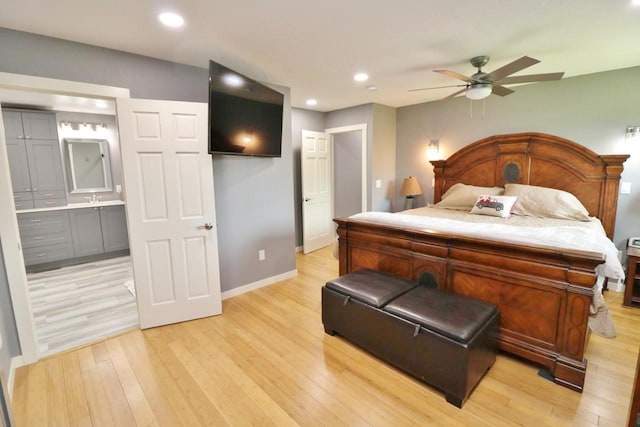 bedroom featuring connected bathroom, light hardwood / wood-style flooring, ceiling fan, and sink