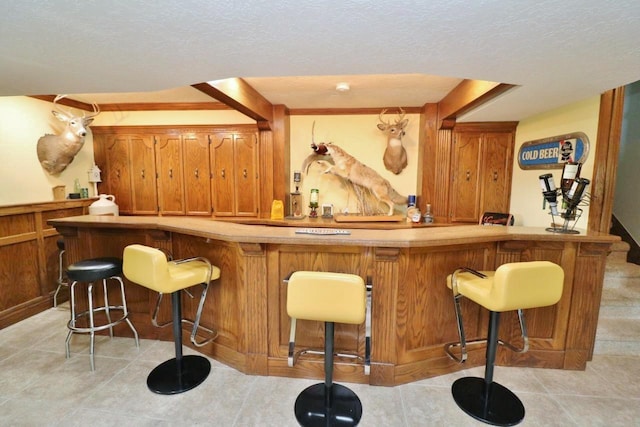 bar featuring light tile patterned flooring and a textured ceiling