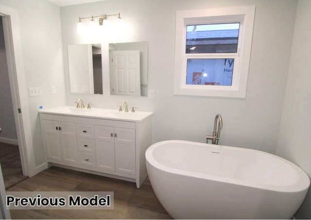 bathroom with vanity, hardwood / wood-style flooring, and a bathtub