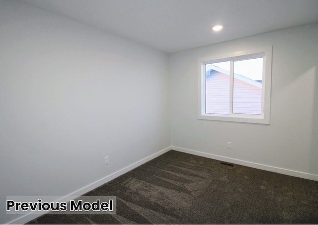 unfurnished room featuring dark carpet