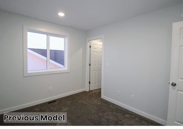 unfurnished room with dark colored carpet