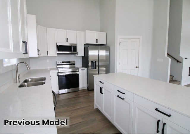 kitchen with sink, white cabinets, stainless steel appliances, and dark hardwood / wood-style flooring