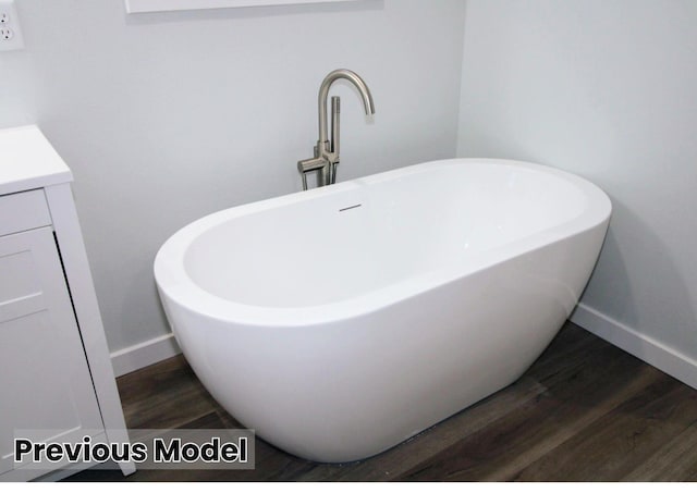 bathroom featuring vanity, wood-type flooring, and a washtub