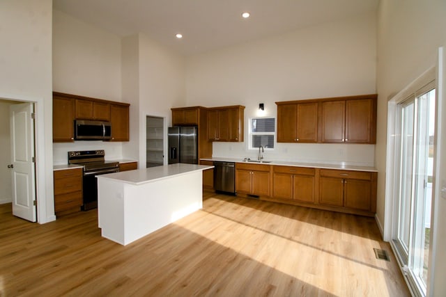 kitchen with a kitchen island, stainless steel appliances, and high vaulted ceiling