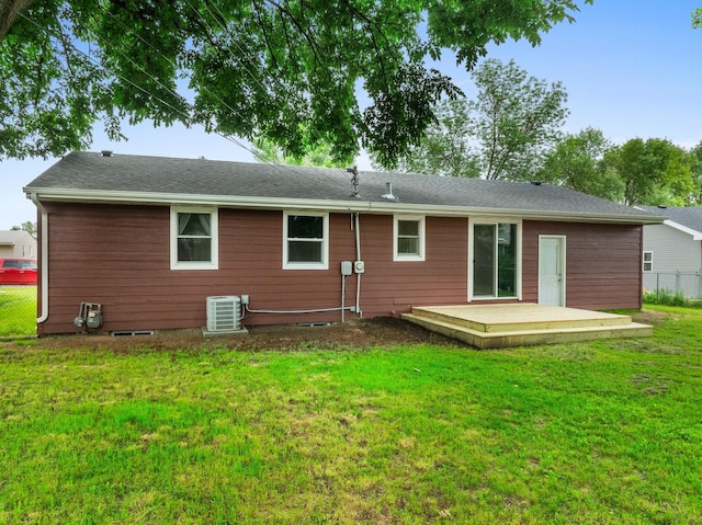 rear view of house featuring a wooden deck and a lawn