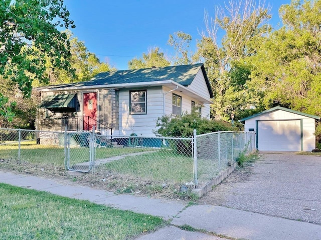 view of front of home featuring a garage, a front yard, and an outbuilding