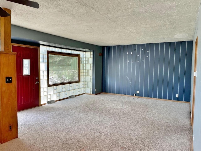 spare room featuring carpet floors and a textured ceiling