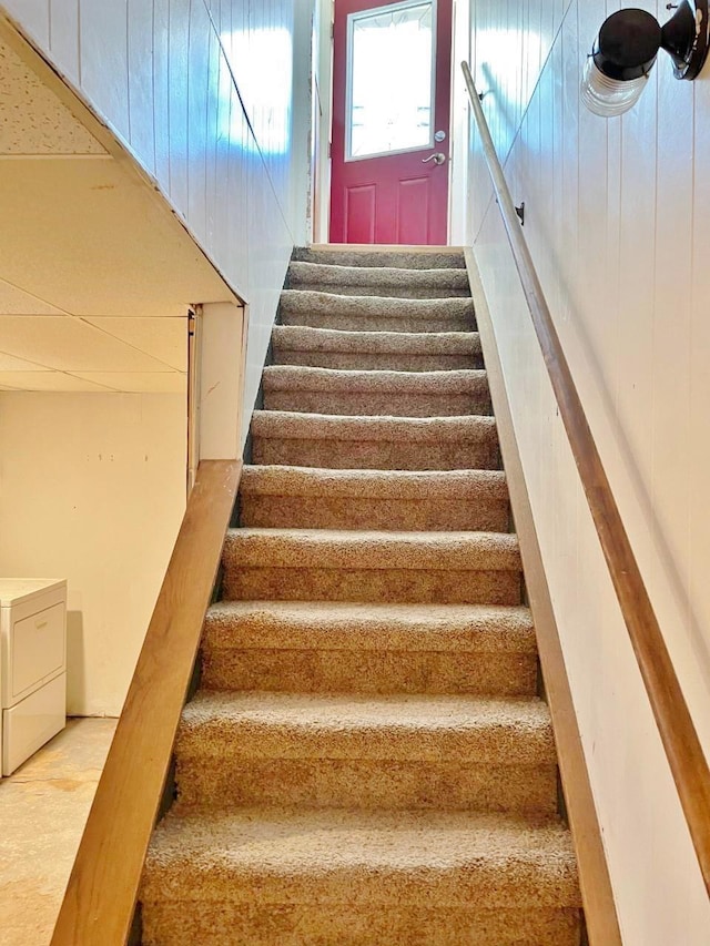 stairs featuring washing machine and dryer