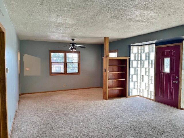 carpeted entrance foyer featuring a textured ceiling and ceiling fan