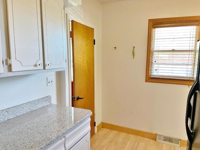 interior space featuring light hardwood / wood-style floors, light stone countertops, white cabinets, and fridge with ice dispenser