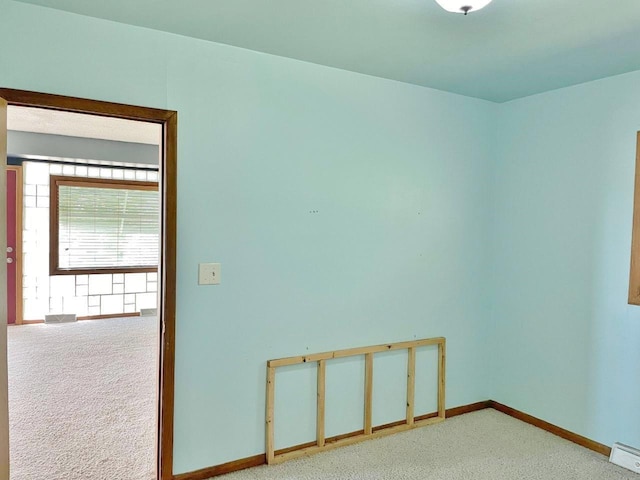 carpeted spare room with a baseboard radiator