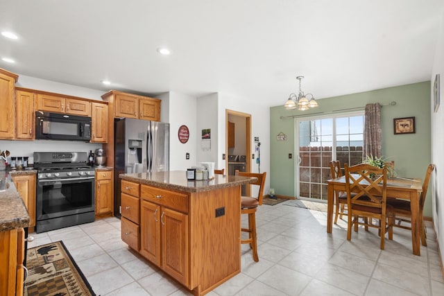 kitchen featuring light tile patterned flooring, a kitchen island, hanging light fixtures, and stainless steel appliances