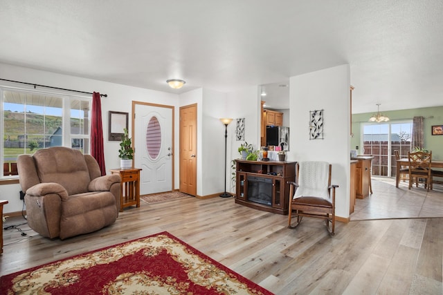 living room with an inviting chandelier and light hardwood / wood-style flooring