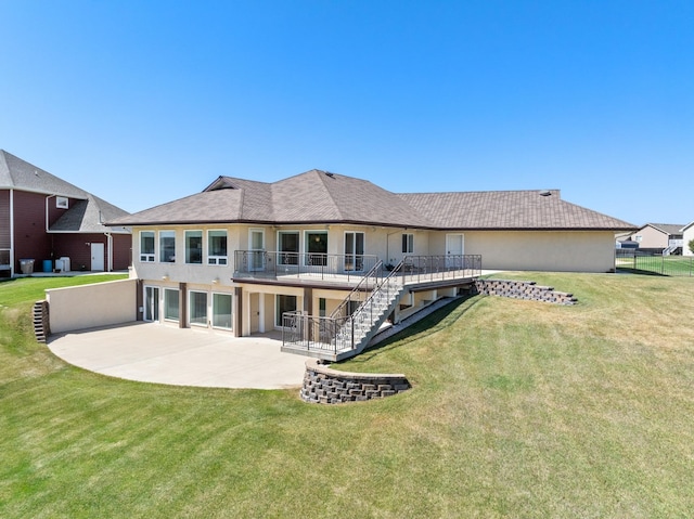 rear view of property featuring a deck, a patio area, and a yard