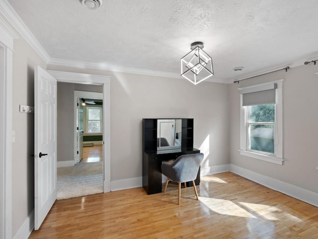 office area featuring crown molding, a textured ceiling, baseboards, and wood finished floors