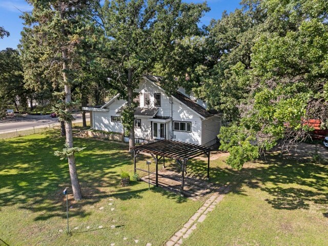 view of front facade featuring a front lawn and a pergola