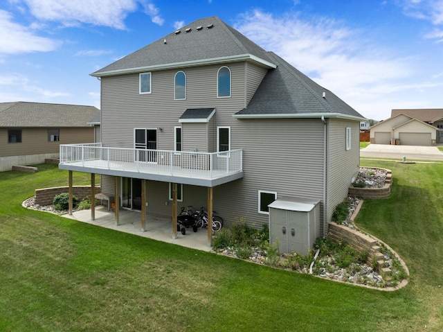 back of property with a patio area, a deck, a lawn, a storage unit, and a garage