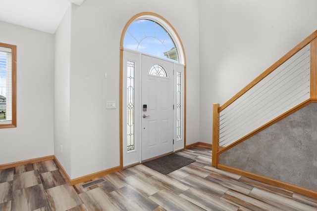 entrance foyer with a wealth of natural light, light hardwood / wood-style floors, and vaulted ceiling