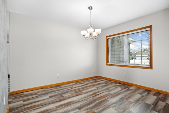 empty room featuring hardwood / wood-style floors and a chandelier