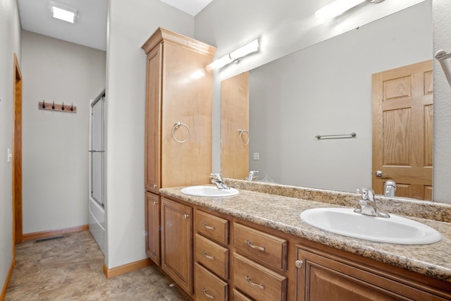 bathroom featuring bath / shower combo with glass door and vanity