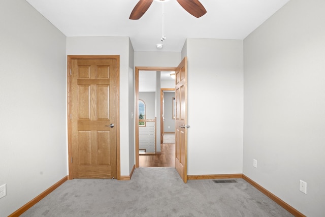 unfurnished bedroom featuring light colored carpet and ceiling fan