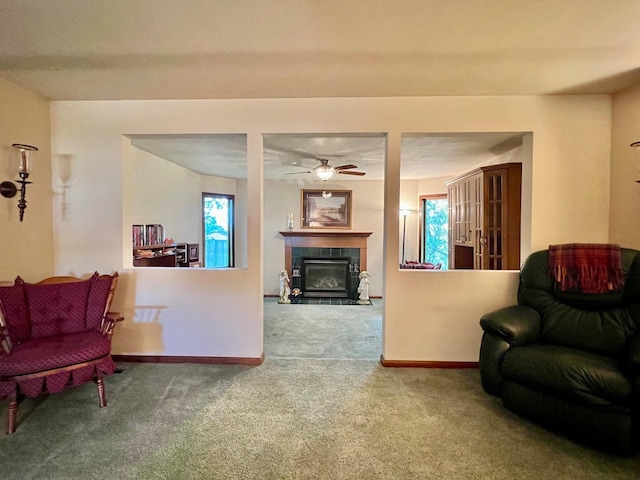 living room with ceiling fan, a tile fireplace, and carpet floors