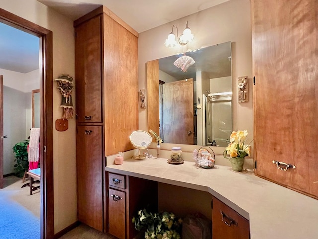 bathroom featuring a shower with door and vanity