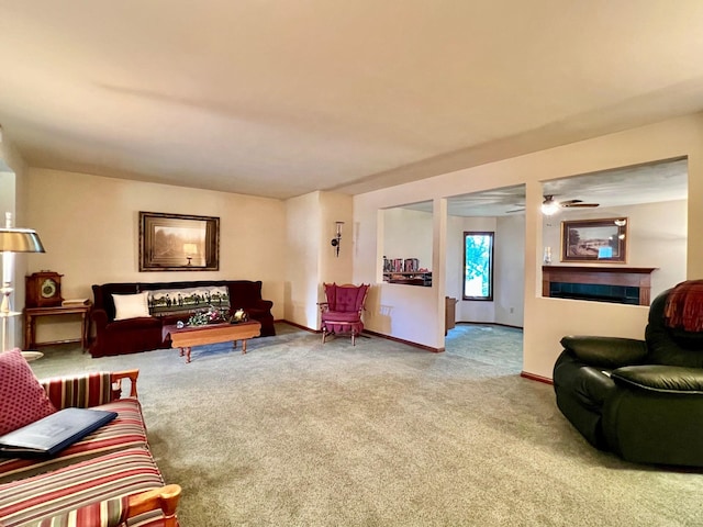 carpeted living room featuring a tiled fireplace and ceiling fan