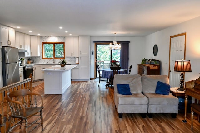 kitchen with under cabinet range hood, light countertops, stainless steel appliances, dark wood-style floors, and white cabinetry