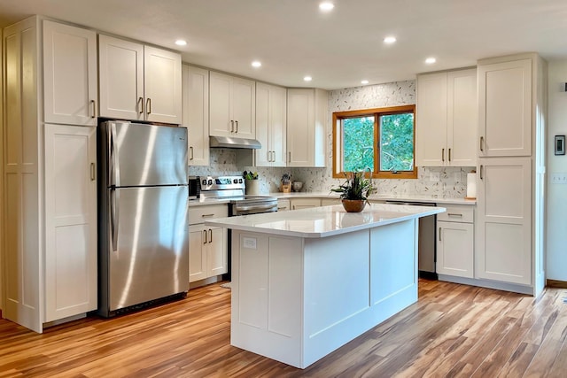 kitchen with white cabinetry, under cabinet range hood, light wood-type flooring, and appliances with stainless steel finishes